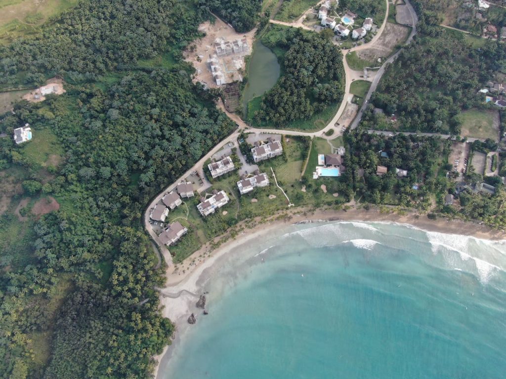 Aerial view of tropical beachfront properties surrounded by lush greenery.