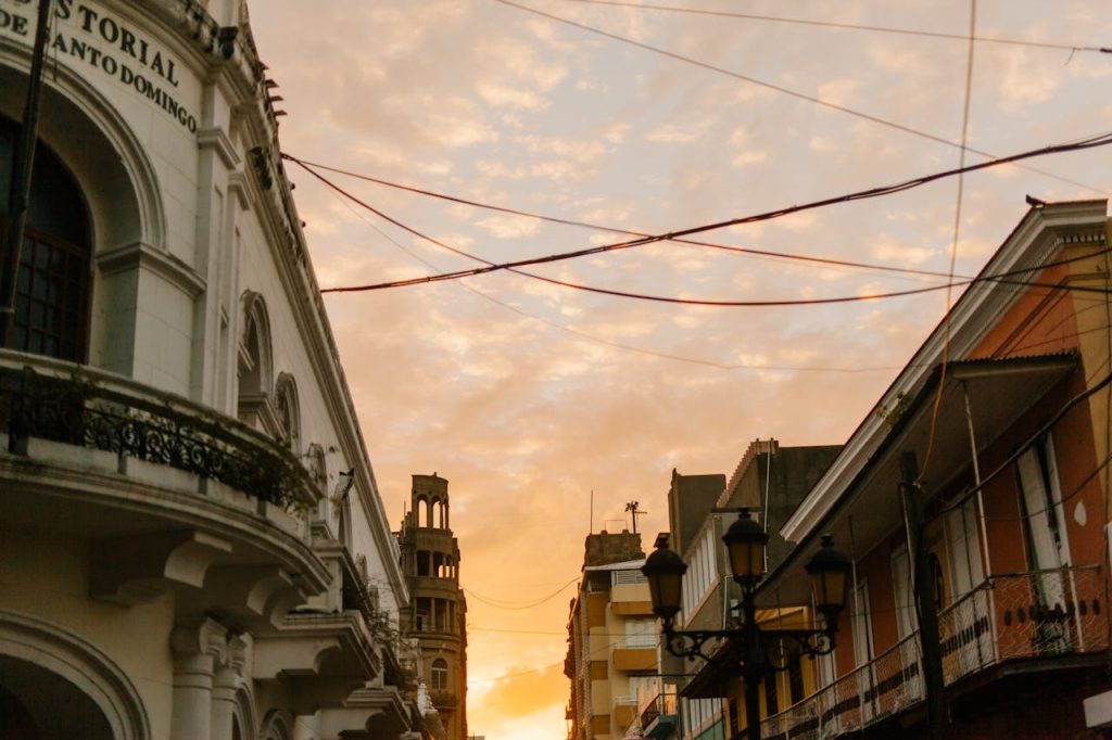 From below of old stone house facades under colorful cloudy sky in city at sundown